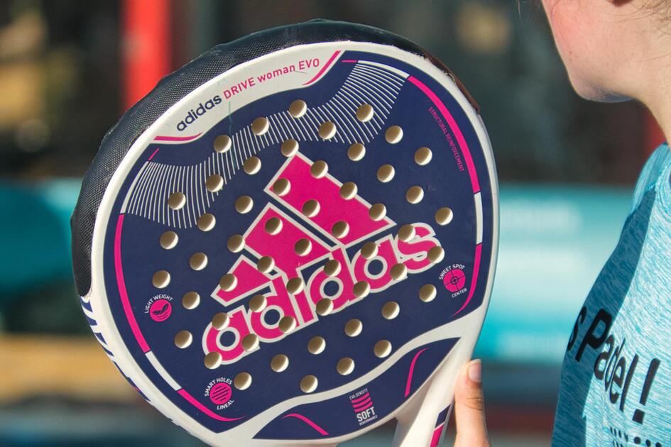 Nahaufnahme einer Person, die einen Padel-Schl&auml;ger mit auff&auml;lligem Adidas-Design in der Hand h&auml;lt.